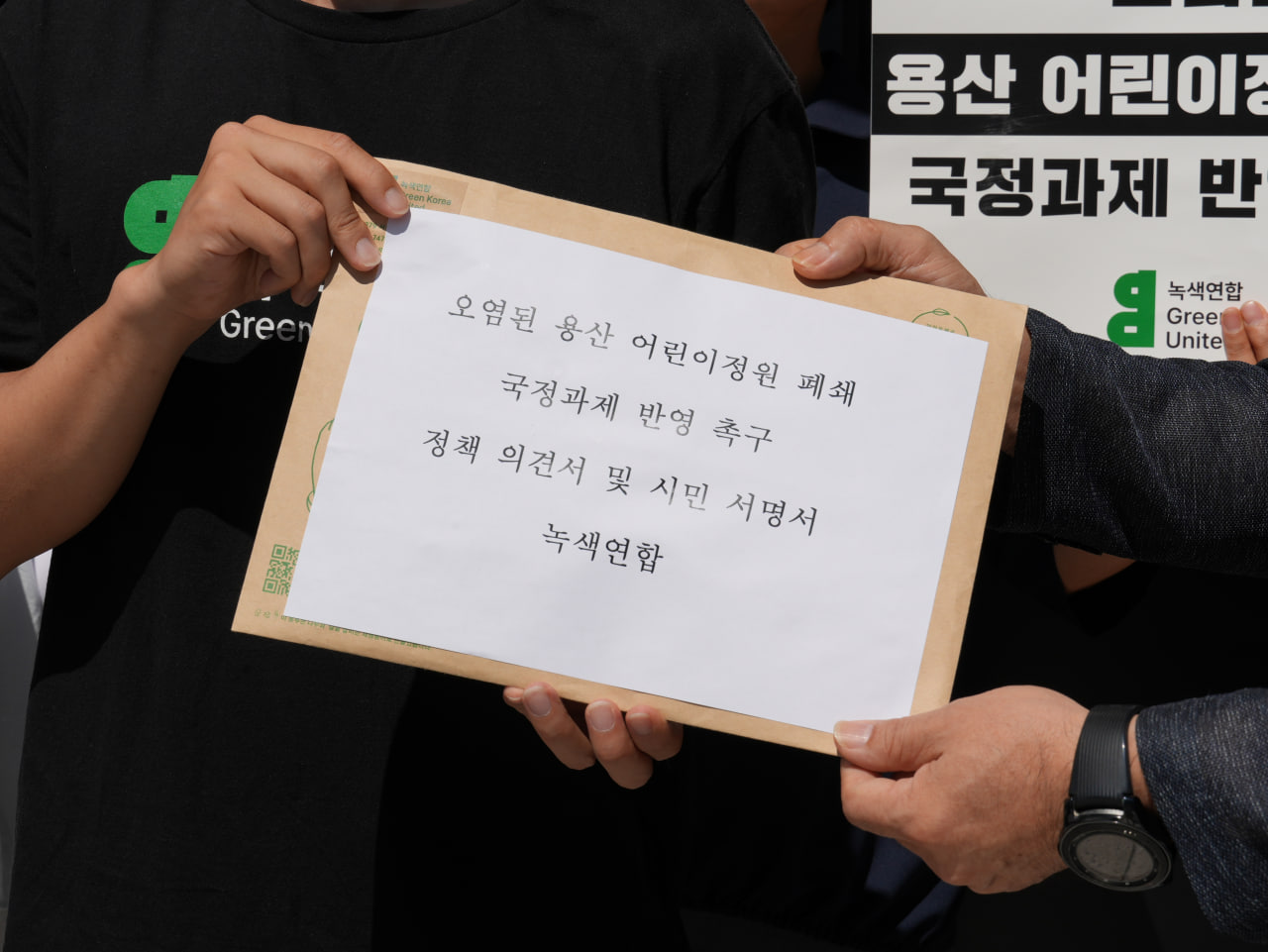 오염된 용산 어린이정원 폐쇄 국정과제 반영 촉구 정책 의견서 및 시민 서명서 전달하는 모습(제공 녹색연합)